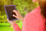 Composite image of elegant brunette using tablet