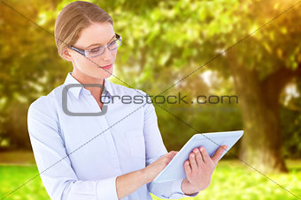 Composite image of businesswoman using tablet pc