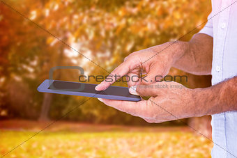 Composite image of a man using tablet computer