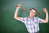 Composite image of geeky hipster holding her pigtails