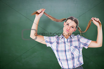 Composite image of geeky hipster holding her pigtails