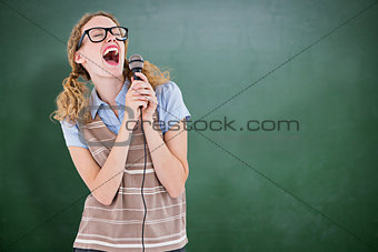 Composite image of geeky hipster woman singing into a microphone