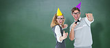 Composite image of happy geeky hispser couple dancing with party hat