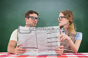 Composite image of geeky hipster couple reading newspaper