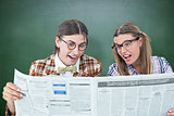 Composite image of geeky hipsters reading the newspaper