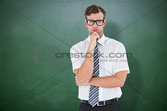 Composite image of serious geeky businessman thinking and holding his chin
