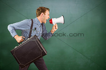 Composite image of geeky hipster shouting through megaphone