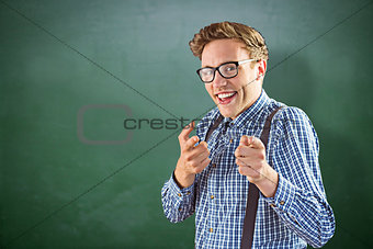 Composite image of geeky hipster pointing at camera