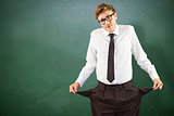 Composite image of geeky businessman showing his empty pockets