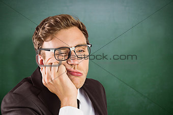 Composite image of young geeky businessman looking bored