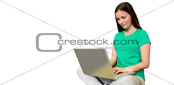 Composite image of student sitting on floor in library using laptop