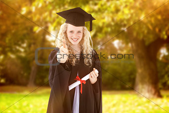 Composite image of teenage girl celebrating graduation with thumbs up