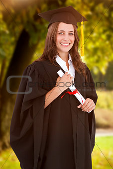 Composite image of a smiling woman with her degree as she looks at the camera