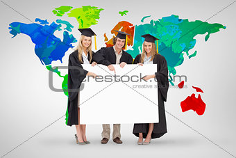 Composite image of three students in graduate robe holding and pointing a blank sign