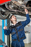 Mechanic checking the condition of a lifted car