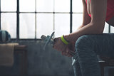 Closeup on fitness woman holding dumbbell in loft gym