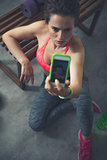Fitness woman sitting in loft gym and taking selfies