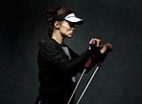 Fit woman training with resistance band against dark background