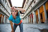 Young fitness female is catching breathe next to Uffizi gallery