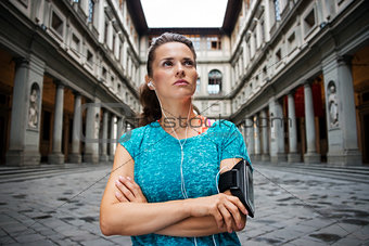 Fitness young woman is staying in front of Uffizi gallery