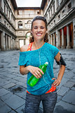 Young smiling sporty woman with bottle of water. Florence