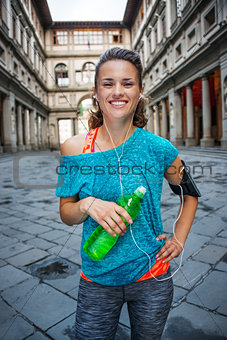 Young smiling sporty woman with bottle of water. Florence
