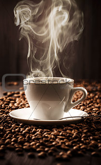 Hot cup of coffee on beans background