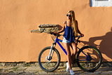 Pretty young hipster blonde girl posing with cycle