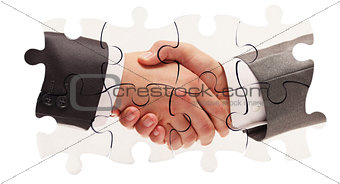 shaking hands inside puzzle pieces