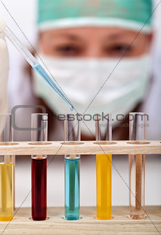 Chemical experiment - woman with pipette and test-tubes