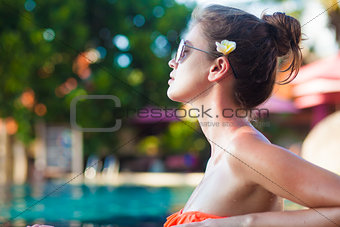 photo of beautiful young woman in luxury pool