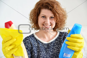 happy woman in rubber gloves with cleaning agents