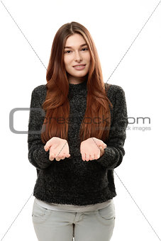 Young woman standing holding her hand showing something