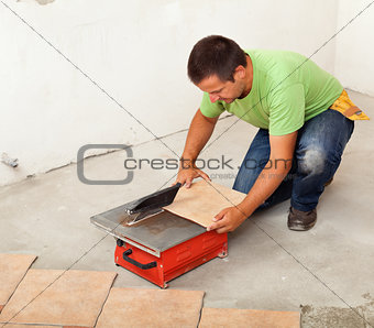 Man cutting ceramic floor tile