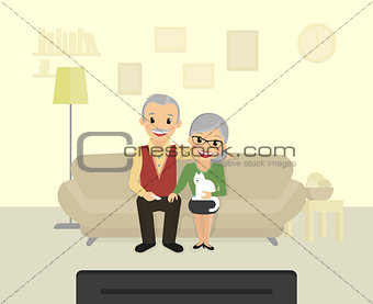Happy grandparents sitting at home and watching a tv