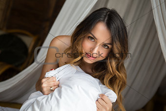 Girl in bed hugging a pillow