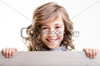laughing little girl from behind a wooden fence
