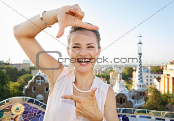 Woman tourist framing with hands in Park Guell, Barcelona, Spain