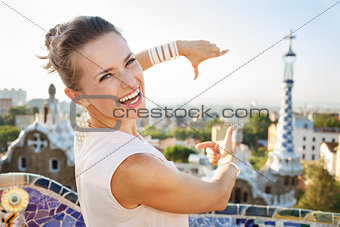 Woman tourist framing with hands in Park Guell, Barcelona, Spain