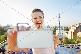 Woman showing thumbs up and taking selfie with mobile, Spain