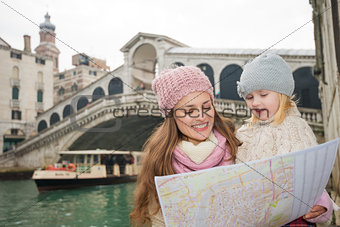 Mother and daughter looking in map in front of Rialto Bridge