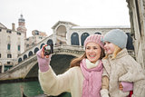 Mother and daughter taking photos in front of Ponte di Rialto