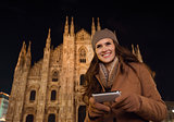 Happy woman writing sms in front of Duomo in evening, Milan