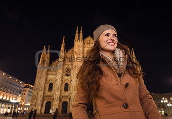 Portrait of happy young woman in the front of Duomo in evening