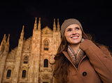 Smiling woman in the front of Duomo in the evening looking aside