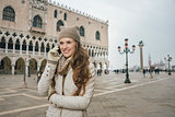 Woman tourist talking cell phone on St. Mark's Square, Venice