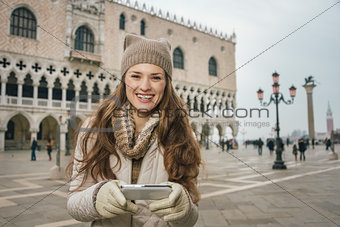 Woman tourist writing sms while standing on St. Mark's Square