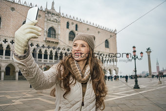 Woman tourist taking selfie with cell phone on St.Mark's Square