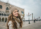 Happy young woman tourist taking photos on St. Mark's Square