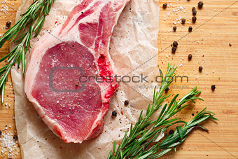 Pieces of crude meat with rosemary and spices